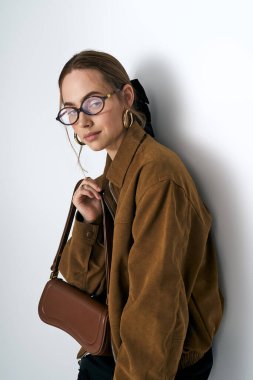 Şık genç bir kadın modern bir ortamda şık bir elbise ve aksesuar giyer..