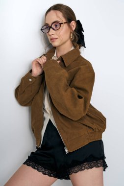 Modaya uygun genç bir kadın zarif bir şekilde poz verir, zarafet ve tarz saçar..