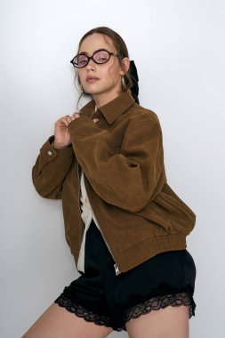 Genç ve güzel bir kadın şık bir kıyafet içinde poz veriyor. Kişisel stili ve kendine güveni var..