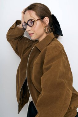 Şık genç kadın, minimalist bir arkaplanda poz verirken eşsiz moda anlayışını sergiliyor..