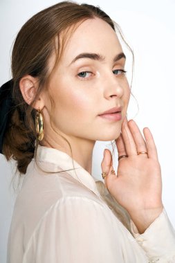 Çekici kadın, şık kıyafeti ve kendine güvenen pozuyla, parlak bir stüdyoda dikkat çekiyor..