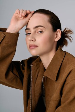 Genç kadın modern modayı özgüvenli bir ifadeyle sergiliyor, zarafet ve modayı yansıtıyor.