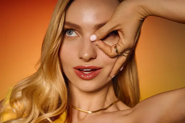 Молодая женщина играет со своими волосами, демонстрируя свой модный стиль в красочной обстановке — стоковое фото