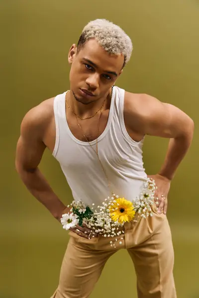 Handsome African American man poses confidently in a tank top surrounded by beautiful flowers. — Stock Photo