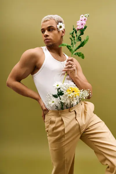 Handsome young African American man poses confidently with flowers, showcasing fashion flair. — Stock Photo