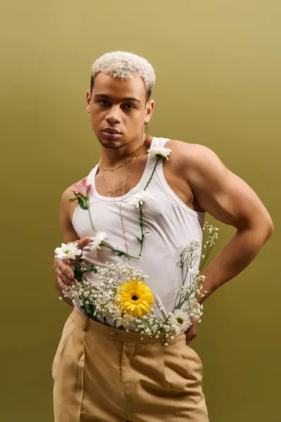 Hombre joven brillantemente vestido con el pelo blanco teñido y flores modelos de su estilo único en la luz del estudio. — Stock Photo