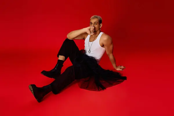 Young man with dyed hair poses in a trendy tank top and black pants, showcasing his style. — Stock Photo