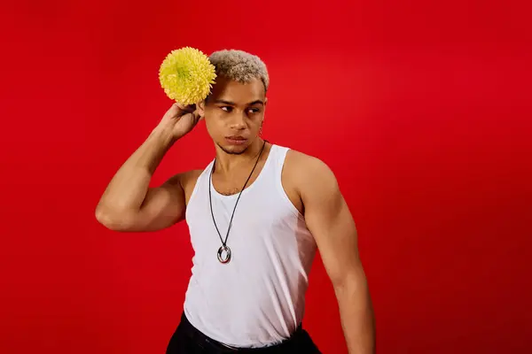 Stylish young man showcases his unique fashion sense in a vibrant red studio setting. — Stock Photo
