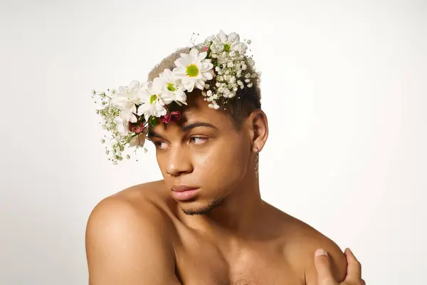 Un jeune homme africain américain torse nu pose élégamment avec une couronne de fleurs, mettant en valeur la beauté. — Photo de stock