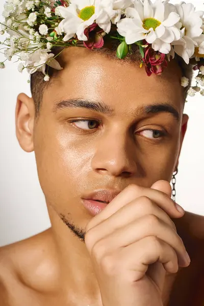 A young Black man poses shirtless with dyed hair and a floral headpiece, radiating confidence. — Stock Photo
