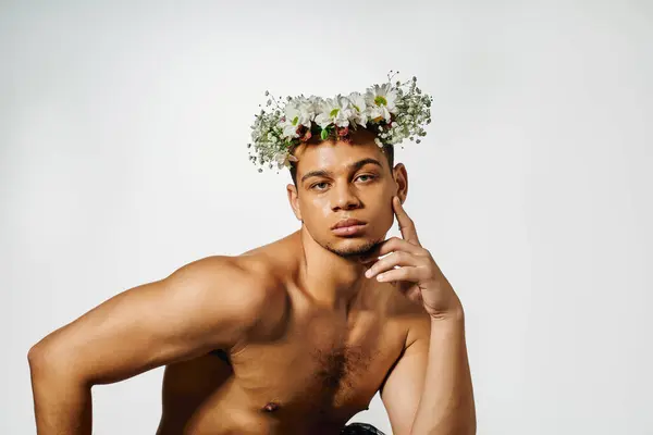 Un joven con el pelo teñido posa con confianza en un estudio mínimo, mostrando su belleza. - foto de stock