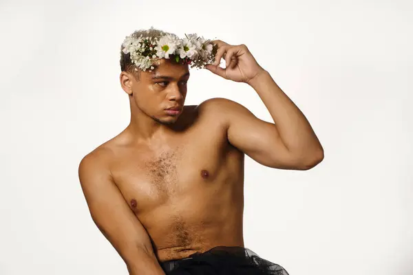 A shirtless young man poses confidently in a studio, highlighting his unique style. — Stock Photo