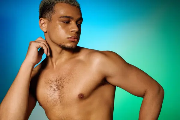 A confident young shirtless Black man poses in a stylish studio, showcasing his beauty. — Stock Photo