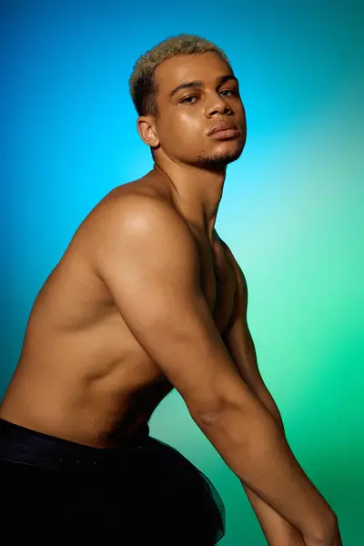 Un joven negro posa sin camisa en un estudio, mostrando su pelo peinado y físico en forma. — Stock Photo