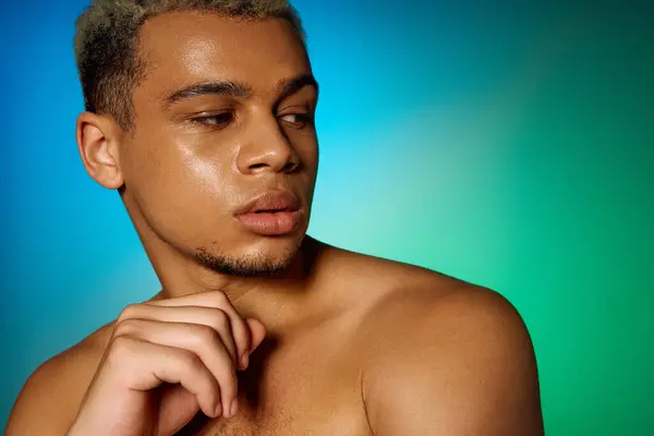 A muscular young man poses confidently in a studio, showcasing his dyed hair and unique style. — Stock Photo