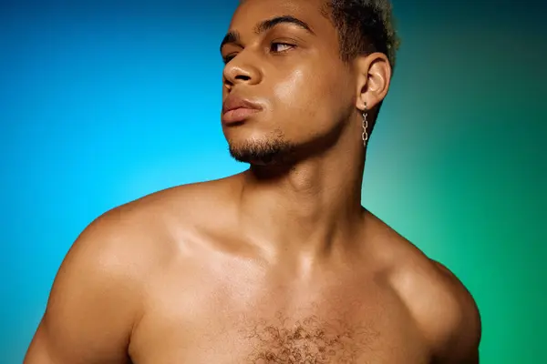 A shirtless young Black man poses confidently, showcasing his style in colorful lighting. — Stock Photo