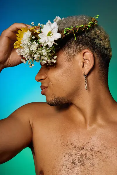 Muscular young man expresses individuality with dyed hair and a floral crown in a studio setting. — Stock Photo