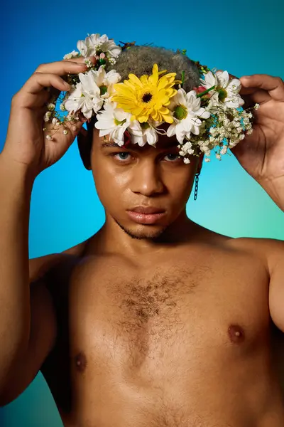 Un jeune Afro-Américain torse nu pose en toute confiance dans un studio, orné de fleurs. — Photo de stock