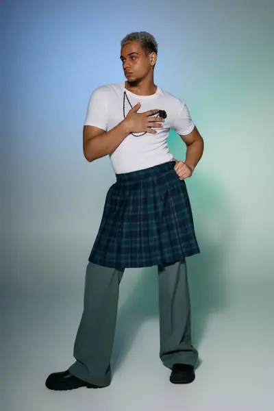 A young African American man with dyed hair confidently posing in a trendy outfit in a studio. — Stock Photo