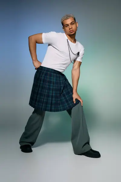 Un jeune homme aux cheveux teints modèle une tenue élégante, mêlant élégance et flair urbain dans un studio. — Stock Photo