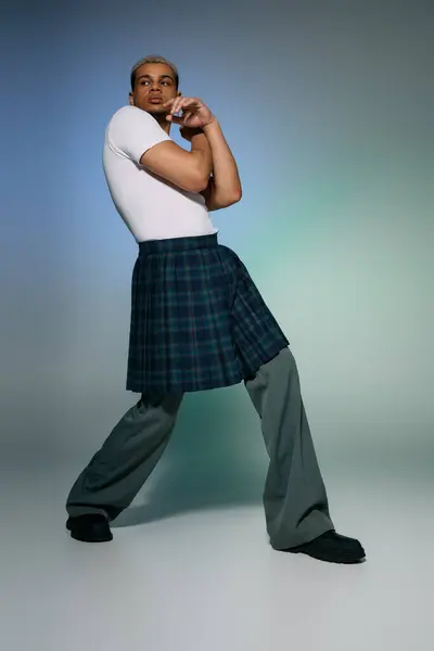 Young man confidently poses in stylish outfit, showcasing unique dyed hair and modern clothing. — Stock Photo