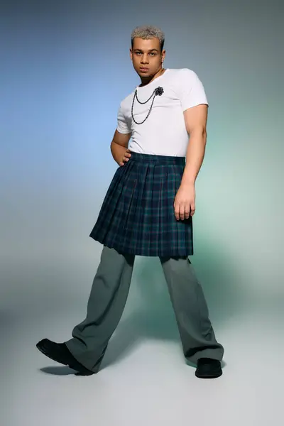 A young african american man with dyed hair confidently poses in a trendy outfit in a studio. — Stock Photo