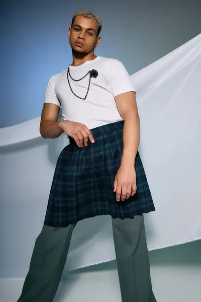 A confident young man poses in unique attire, blending styles with dyed hair and bold choices. — Stock Photo