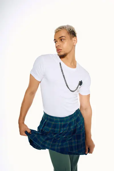 A young african american man confidently poses in a fashionable outfit, expressing modern style. — Stock Photo