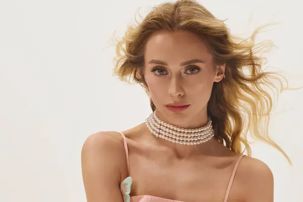 Une jeune femme aux cheveux blonds fluides met en valeur son sens de la mode dans un cadre chic et minimal. — Photo de stock