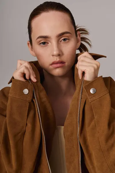 Una donna giovane e bella mette in mostra il suo stile unico con una giacca alla moda, in posa con grazia. — Foto stock