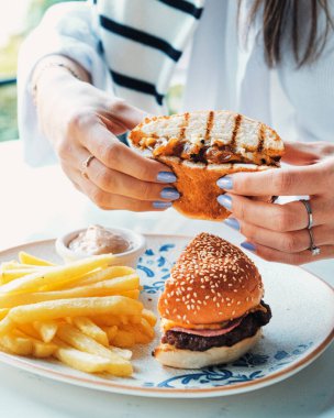 Izgara et, sebze ve sos ile nefis bir burger. Fast food ve abur cubur kavramı.