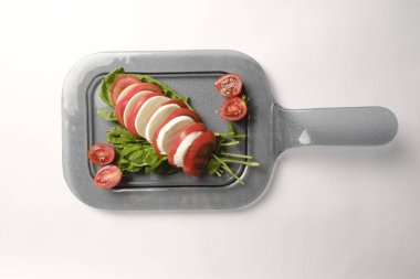 Pesto soslu bir tabak lezzetli Caprese salatası.