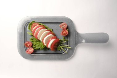 Pesto soslu bir tabak lezzetli Caprese salatası.