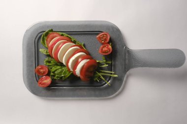 Pesto soslu bir tabak lezzetli Caprese salatası.