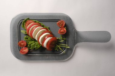 Pesto soslu bir tabak lezzetli Caprese salatası.