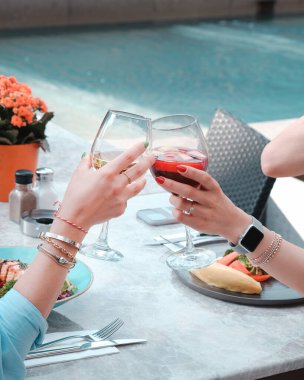 Şarap içen genç kadınlar, mutlu arkadaşlar restoranda mutlu saatler geçiriyorlar.  