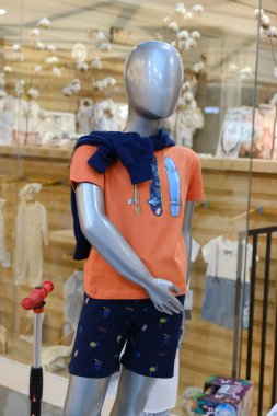 Çocuk kıyafetleri mağazadaki rafta asılı.