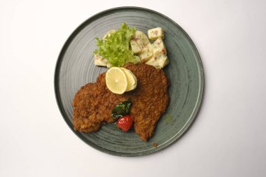 Patates kızartmasıyla servis edilen lezzetli şnitzel.