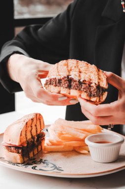 Izgara et, sebze ve sos ile nefis bir burger. Fast food ve abur cubur kavramı.