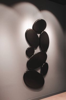 Kadın sergideki eserlere ve sergideki eserlere bakıyor.