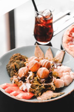 Sebzeli, zeytinli, otlu ve yoğurt soslu falafel salatası kasesi..