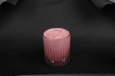 Bir bardak ahududu milkshake, krem şanti ve taze ahududu.