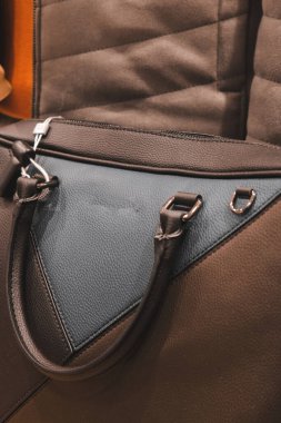 Dükkanda çanta takan ve elinde çanta tutan bir kadın.