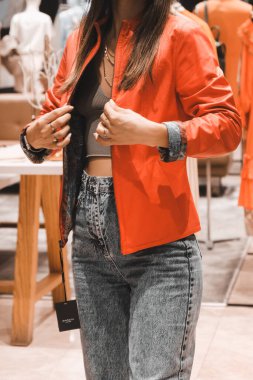 Giysiler mağazadaki rafta asılı.