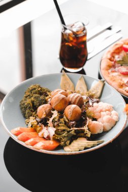 Sebzeli, zeytinli, otlu ve yoğurt soslu falafel salatası kasesi..