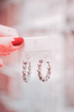 Kadın alışveriş merkezinde kıyafetlere ve alışverişe bakıyor.