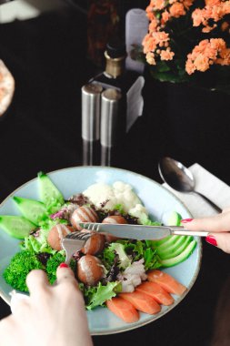 Sebzeli, zeytinli, otlu ve yoğurt soslu falafel salatası kasesi..