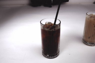 Sütlü buzlu kahve. Buzlu kahve. Elinde bir bardak buzlu kahve tutan kadın..