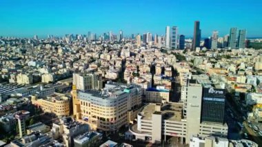 İsrail, 31 Mart 2023, güneşli bir günde, kırmızı kiremitli eski evlerin ve Bnei Brak şehrinin sokaklarının havadan görünüşü. Ufukta Tel Aviv gökdelenleri görünüyor. Yüksek kalite 4K görüntü