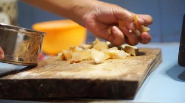 Bir kadının eli mutfak bıçağıyla sığır derisi kesiyor.